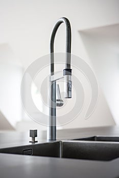 a modern kitchen sink with stainless steel fixtures in a newly renovated house