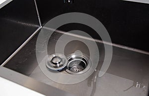 Modern stainless steel sink with drain plug. Water filling. Copy space for text