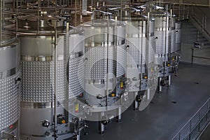 Modern stainless steel wine vats in winery interior