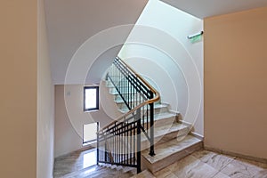 Modern stair case between floors. Stairs with metallic rail in modern building