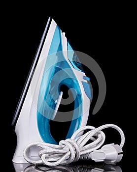 Modern steam iron isolated on black background.