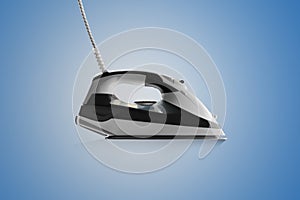 Modern steam iron side view on blue background