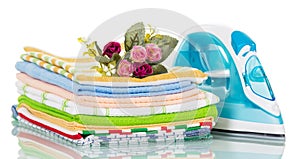 Modern steam iron and stack of towels, rose isolated.