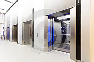 Modern steel elevator opened cabins in a business lobby or Hotel