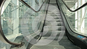 Modern steel and glass elevator is going down inside airport terminal.