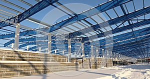 Modern storehouse construction site, the structural steel structure of a new commercial building against a clear blue