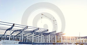 Modern storehouse construction site, the structural steel structure of a new commercial building against a clear blue