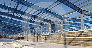 Modern storehouse construction site, the structural steel structure of a new commercial building against a clear blue