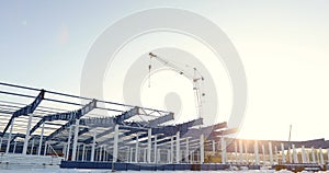 Modern storehouse construction site, the structural steel structure of a new commercial building against a clear blue