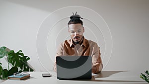 Modern student typing keyboard at workplace. Focused man watching screen at home