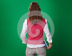 Modern student woman with blue notebook isolated on green