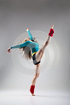 Modern style dancer posing on grey background