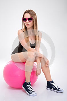 Modern style dancer posing on pink fitball