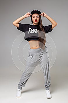 Modern style dancer posing on studio background. Hip hop, jazz funk, dancehall