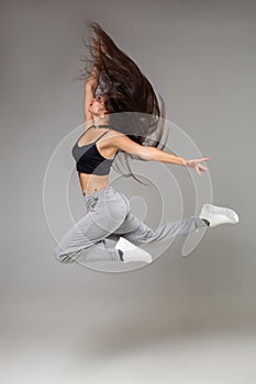 Modern style dancer posing on studio background. Hip hop, jazz funk, dancehall