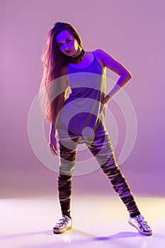 Modern style dancer posing on studio background. Hip hop, jazz funk, dancehall