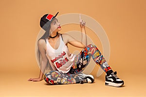 Modern style dancer posing on studio background. Hip hop, jazz funk, dancehall