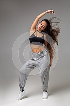 Modern style dancer posing on studio background. Hip hop, jazz funk, dancehall photo