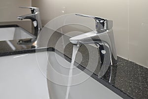 Modern style faucet with under counter wash basin in restroom