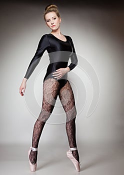Modern style woman ballet dancer full length on gray