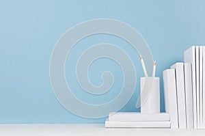 Modern style workplace - white stationery on soft blue background and light desk with copy space.