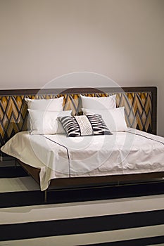 Modern stylish bedroom, double bed with headrest in the Art Nouveau style, retro, with a zigzag pattern, loft bedroom