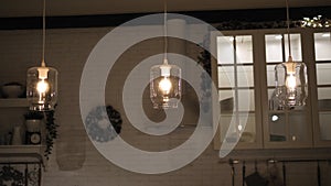 Modern stylish lamps made of glass jars in the kitchen above the table.