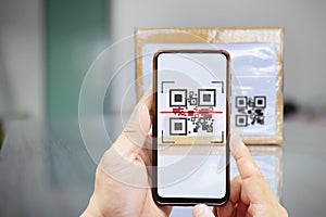 Modern stylish mobile phone scanning QR code on box