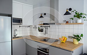 Modern stylish Scandinavian kitchen interior with kitchen accessories. Bright white and grey kitchen with household items