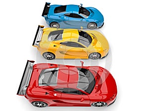 Modern super sports cars in red, yellow and blue parked side by side - top down view