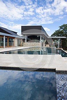 Modern swimming poolside with a luxury house or hotel