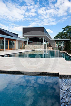 Modern swimming poolside with a luxury house or hotel photo