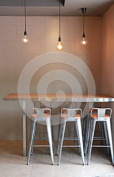 Modern table counter bar with chairs loft interior with gray tile wall and hanging decor lamps