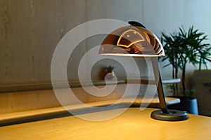 Modern table lamp on the wooden table. desk lamp illuminate - with copy space for text