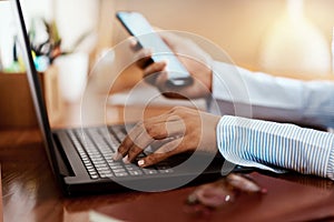 Modern tech gives us many ways to connect. Cropped shot of a businesswoman using a laptop and smartphone at her desk.