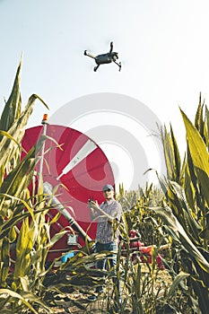 Modern technological farmer analyzing the growth of corn by flying a drone