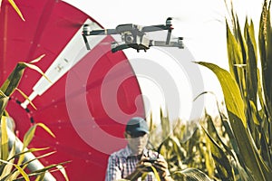 Modern technological farmer analyzing the growth of corn by flying a drone
