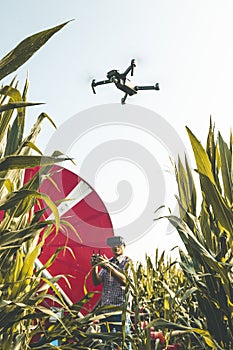 Modern technological farmer analyzing the growth of corn by flying a drone