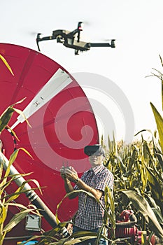 Modern technological farmer analyzing the growth of corn by flying a drone