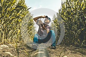Modern technological farmer analyzing the growth of corn by flying a drone over his cultivated fields