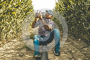 Modern technological farmer analyzing the growth of corn by flying a drone over his cultivated fields