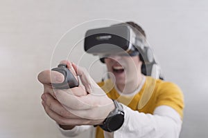 Modern technologies and domestic entertainment concept. Young man trying virtual reality at home, using headset VR