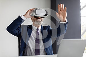 Modern Technologies. Excited Middle Aged Businessman Using VR Glasses In Office