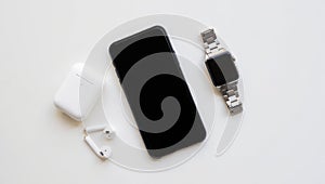 Modern technology setup featuring smartphone earbuds and smartwatch