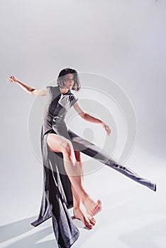 Modern teen contemporary dancer poses in front of the studio background.