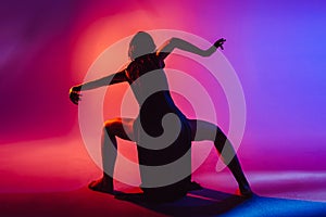 Modern teen contemporary dancer poses in front of the studio background.