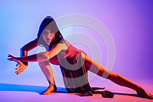 Modern teen contemporary dancer poses in front of the studio background.