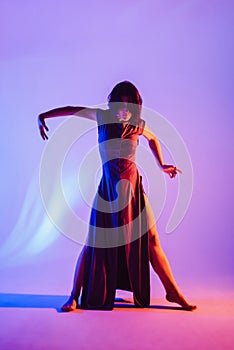 Modern teen contemporary dancer poses in front of the studio background.