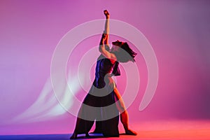 Modern teen contemporary dancer poses in front of the studio background.