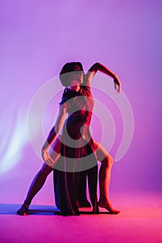 Modern teen contemporary dancer poses in front of the studio background.